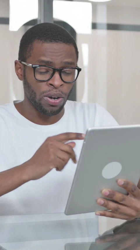 Young African Man Doing Video Chat on Tablet in Office, vertical video Stock Footage 324691097