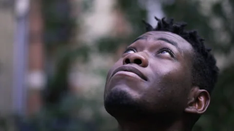 Young African man face close-up looking up with HOPE and FAITH Stock Footage 151429752