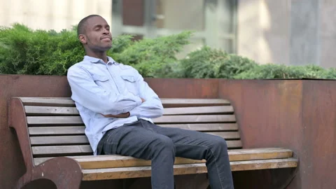 Young African Man having Back Pain while standing up from Bench Video stock 136033372