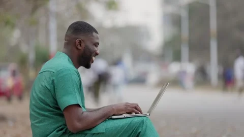 Young African Man with Laptop Computer, checks school admission status online. Stock Footage 345506272