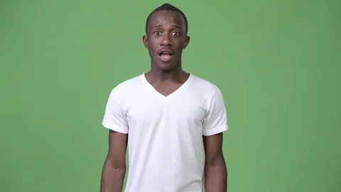 Young African man looking excited against green background Stock Footage