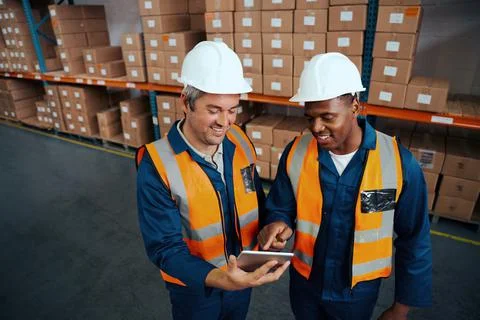 Young african man pointing something to his coworker over digital tablet in Stock Photos