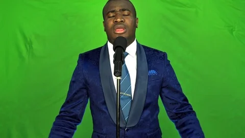 Young african man singing over green background and looking at camera. 動画素材 74877683