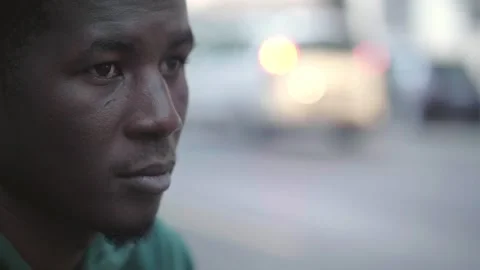 A young African man sits in deep thought, embodying urban solitude Stock Footage 265568022