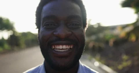 Young african man smiling on camera in the city with sunset in the background Stock Footage 158221839