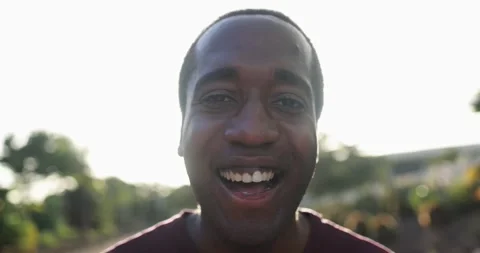 Young african man smiling on camera in the city with sunset in the background Stock Footage 158221856