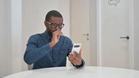Young African Man Typing Message on Phone at Workspace Stock Footage 309508435