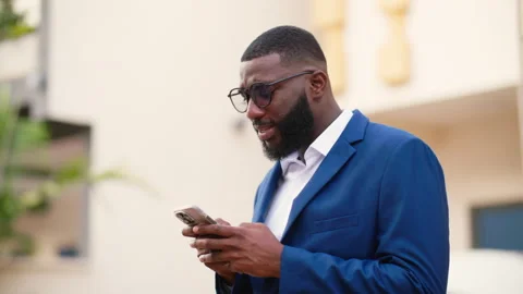 Young African Man Using Smartphone Outdoors for Mobile Banking Video stock 346007787