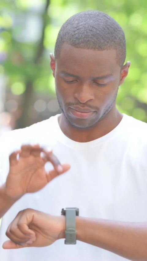 Young African Man Using Smartwatch Outdoor in Park, Vertical Video Stock Footage 319024604