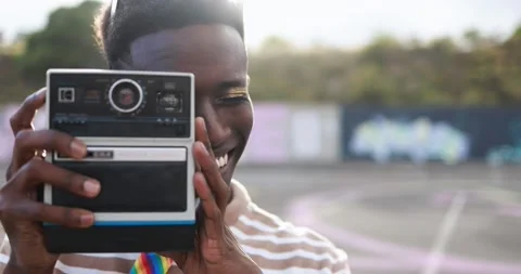 Young african man using vintage old camera outdoor Stock Footage 185514232