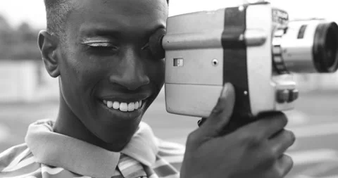 Young african man using vintage old video camera outdoor Stock Footage 185514890