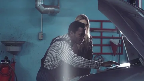 Young african mechanic diagnoses engine Vídeos de archivo 70790901