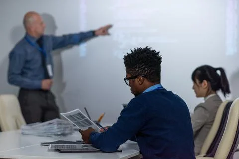 Young African programmer working with papers at seminar Stock-Fotos