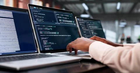 Young African Woman Coding Secure Software On Laptop In Busy Office. Stock Photos