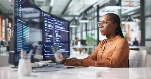 Young African Woman Engineer Coding Secure Software On Laptop In Modern Offic Stockfoto's