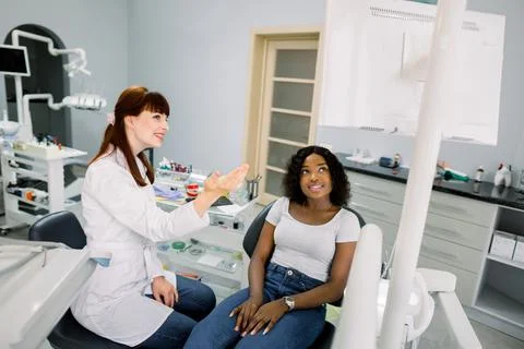 Young african woman patient sitting in dentistry chair and looking on the Stock Photos