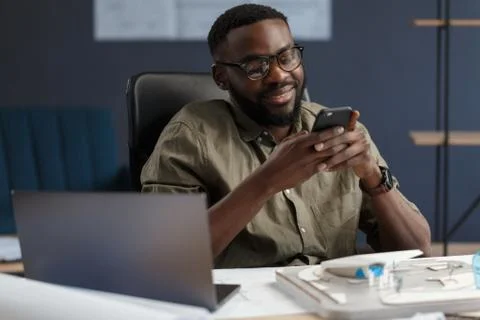 Young Afro-American man using smartphone and smiling. Happy businessman using Foto stock