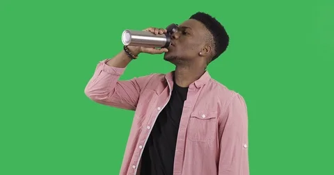 Young afro guy opens the lid in a thermo mug and drinks coffee. Stock Footage 83891790