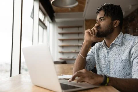 Young afro guy think before typing correct answer on pc Foto stock