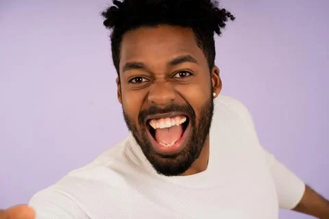 Young afro man looking at camera and taking a selfie. Stock Photos