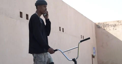 Young afro man rapper talking on the phone in the street.Young millennial urb Stock Footage 151484329
