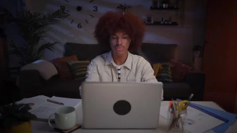 Young afro man working concentrate from home using laptop and taking notes Stock Footage 261223888