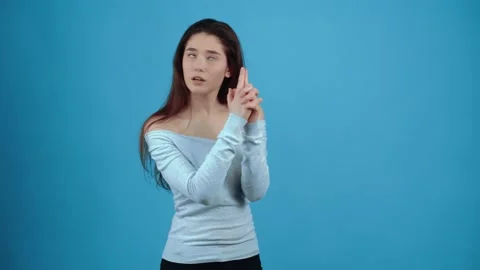 The young agent simulates a handgun, spies, then simulates a shot and blows Stock Footage 154688370