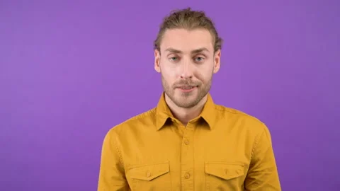 Young aggressive long-haired guy showing blah blah gesture on isolated purple Stock Footage 149044196