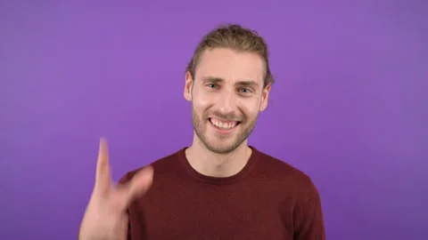 Young aggressive long-haired guy showing blah blah gesture on isolated purple Stock Footage 149327337