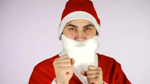Young aggressive man in santa claus suit in boxer pose isolated over white wall Stock Footage 142403448