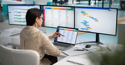 Young Agile Project Manager Updates Daily Task List On Laptop. Stock Photos