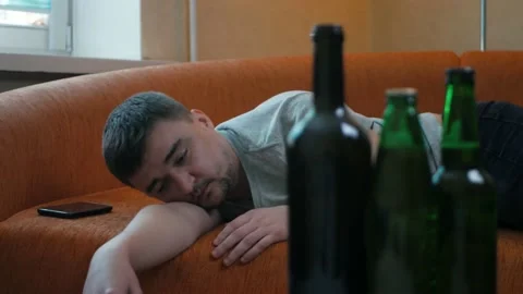 Young alcoholic waking up in the bed after alcohol abuse and drug addicted Stockbeeldmateriaal 197079232