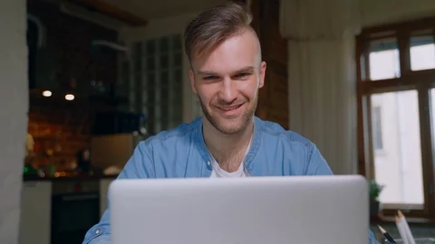 Young american guy is having video call at table with laptop during quarantine Stock Footage 128970050