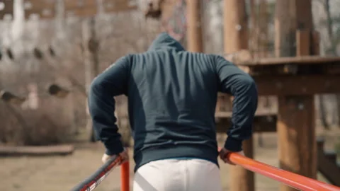 Young american man is pulling up on horizontal bar while training in city park. Stock Footage 133214071