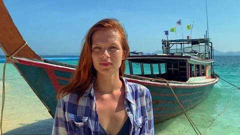 Young american woman is posing while standing on background of boat on tropical Vídeo Stock 129082643
