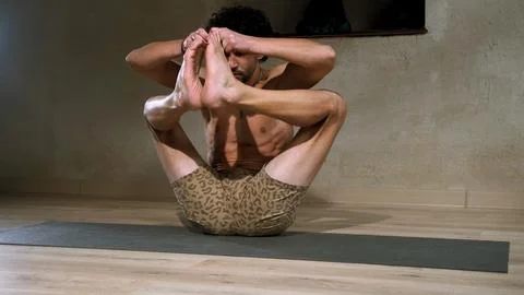 A young and athletic man does yoga and performs asanas. Foto stock