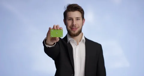 Young and attractive man presenting a buisness card into the camera Stock-Footage 99307087