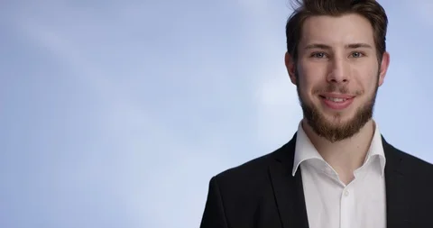 Young and attractive man smiling and raising a buisness card into the camera Stock Footage 99307403