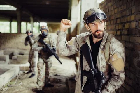 Young and bearded guy is standing and looking right. He is serious and Stock Photos