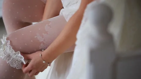 Young and beautiful bride is checking garter stocking Stock Footage