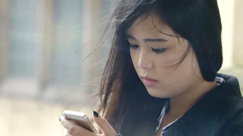 Young and  beautiful chinese using cell phone to send messages Stock Footage 57095365