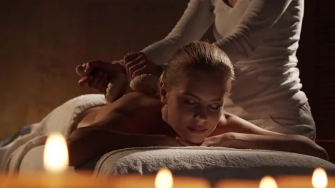 Young and beautiful woman gets herbal ball massage therapy in the spa salon Stock Footage 145213053