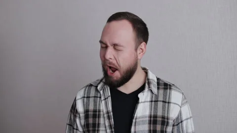 Young and charming bearded man winking at camera isolated on a gray background  Stock Footage 300853436