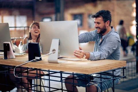 Young and creative man and woman in the office working on project. Joyful m.. Stock Photos
