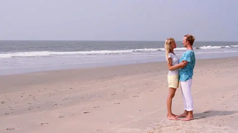 Young and cute couple joy on the beach. Honeymoon near ocean. Video stock 26243733