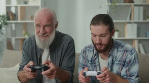 Young and elderly man happily spending time playing a computer game Stock Footage 263401685