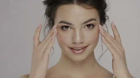 Young and fresh model treating her face and neck with smile Stock Footage 113290075