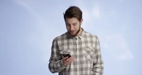 Young and good looking man typing on his phone and showing the display into t Stock-Footage 99414983