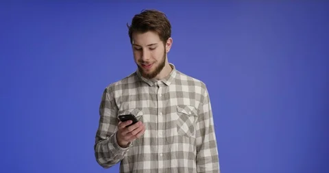 Young and good looking man typing on his phone and showing your product to th Stock-Footage 99416038