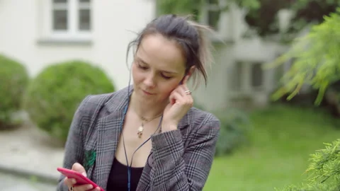 Young and happy woman is putting her headphones, listening to yhe music, singing Stock Footage 146520341